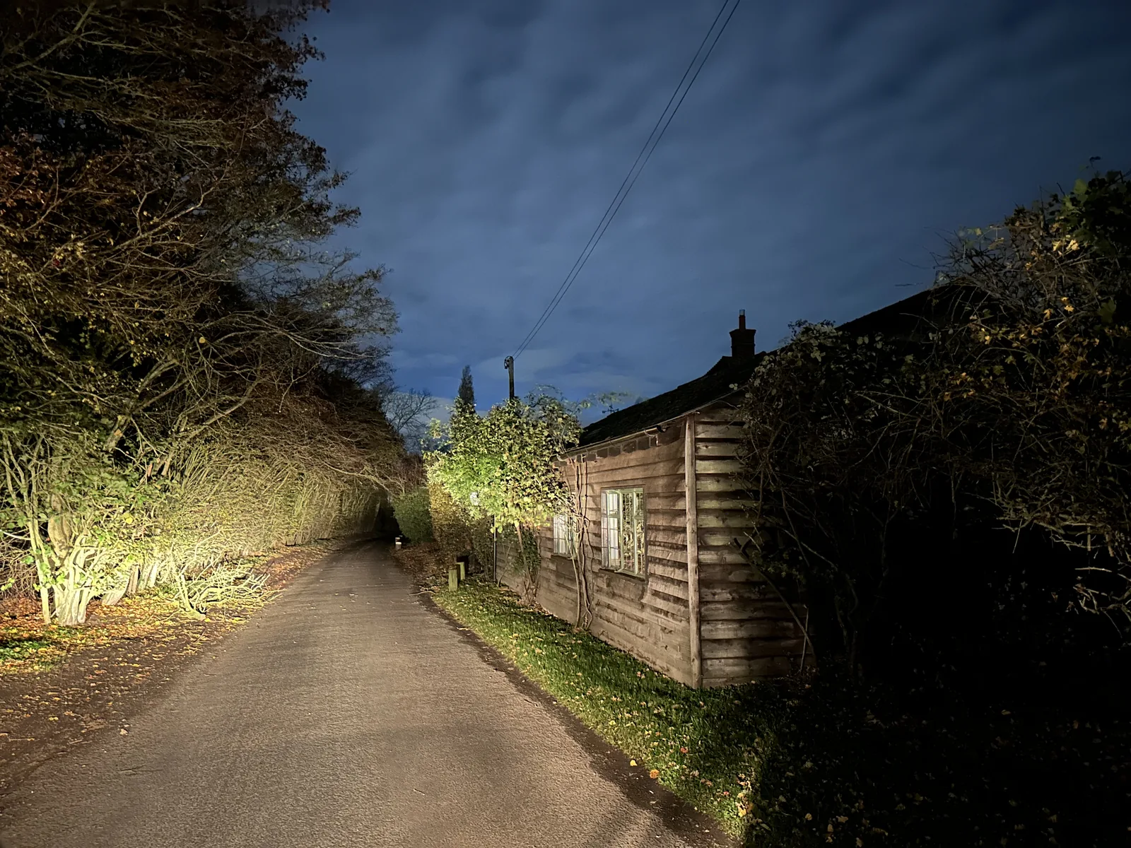 A narrow Little Braxted lane and timber building at night