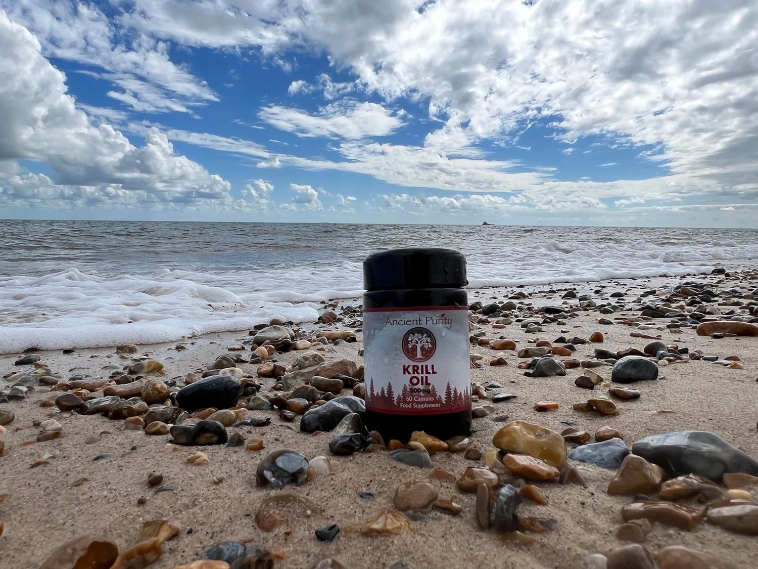 Ancient Purity Krill Oil bottle on a beach